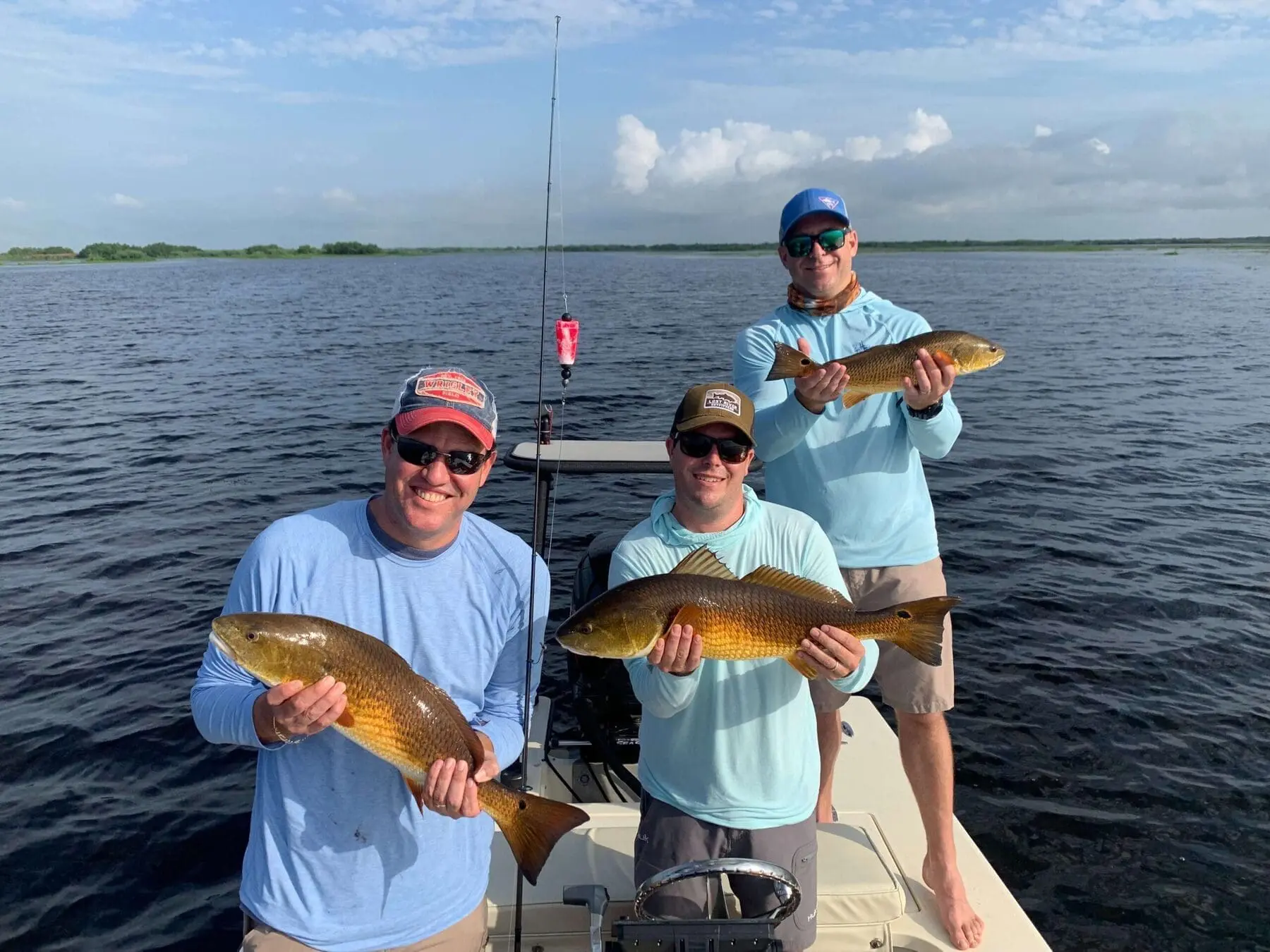 Clients holding redfish on Louisiana fishing charter